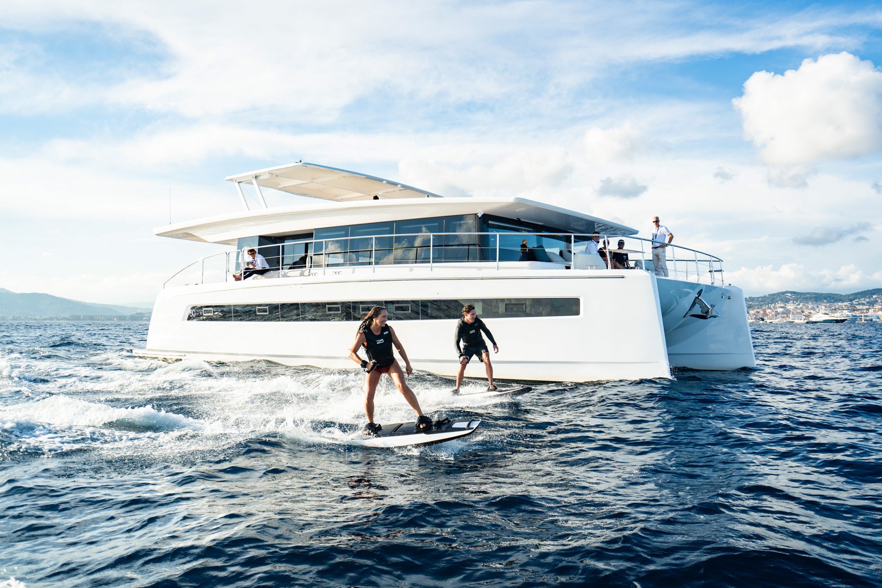Two RAVIK Jetboard riders with backdrop of a yacht.