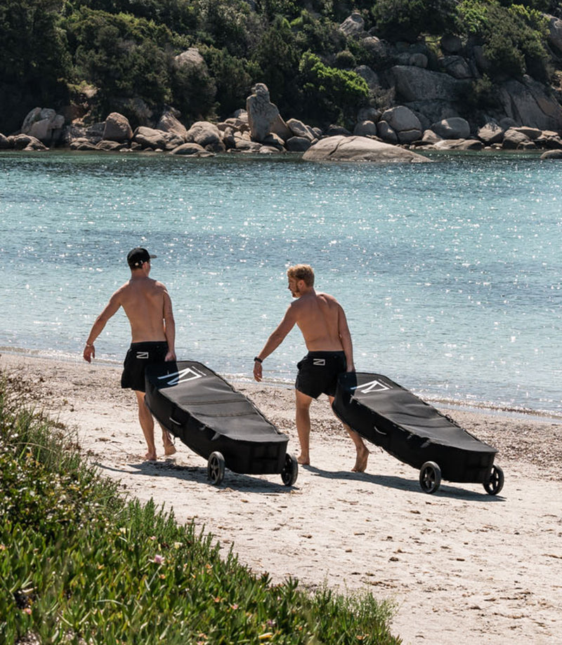 Two men carrying the RAVIK Board Bag Kits to the Beach