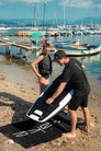 A man setting up the Awake VINGA efoil using an Awake Beach Mat