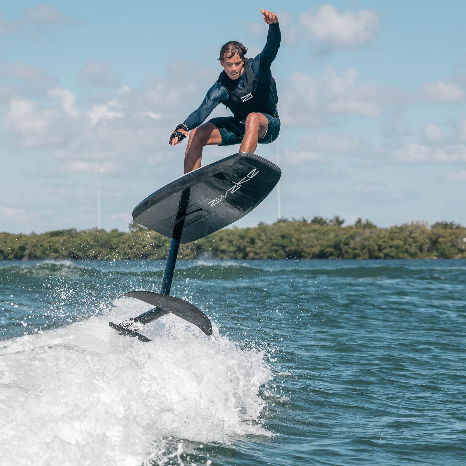 A man jumping with the VINGA S over the wake of a boat.