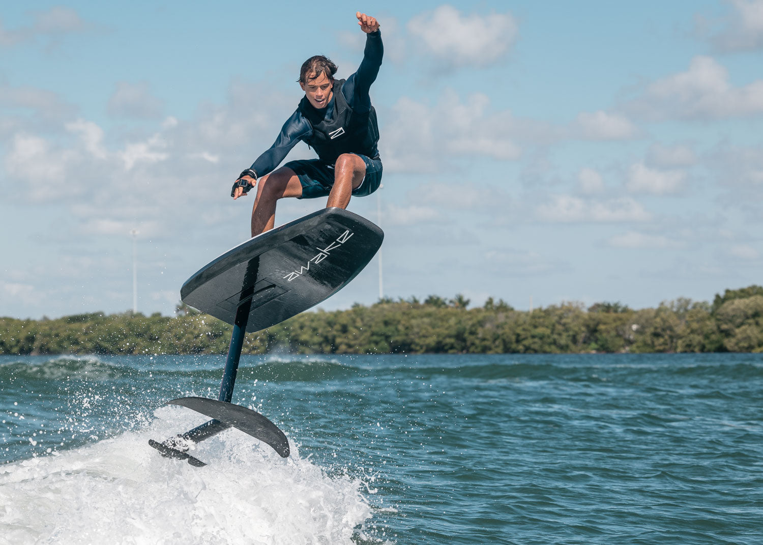 A man jumping with the VINGA S over the wake of a boat.