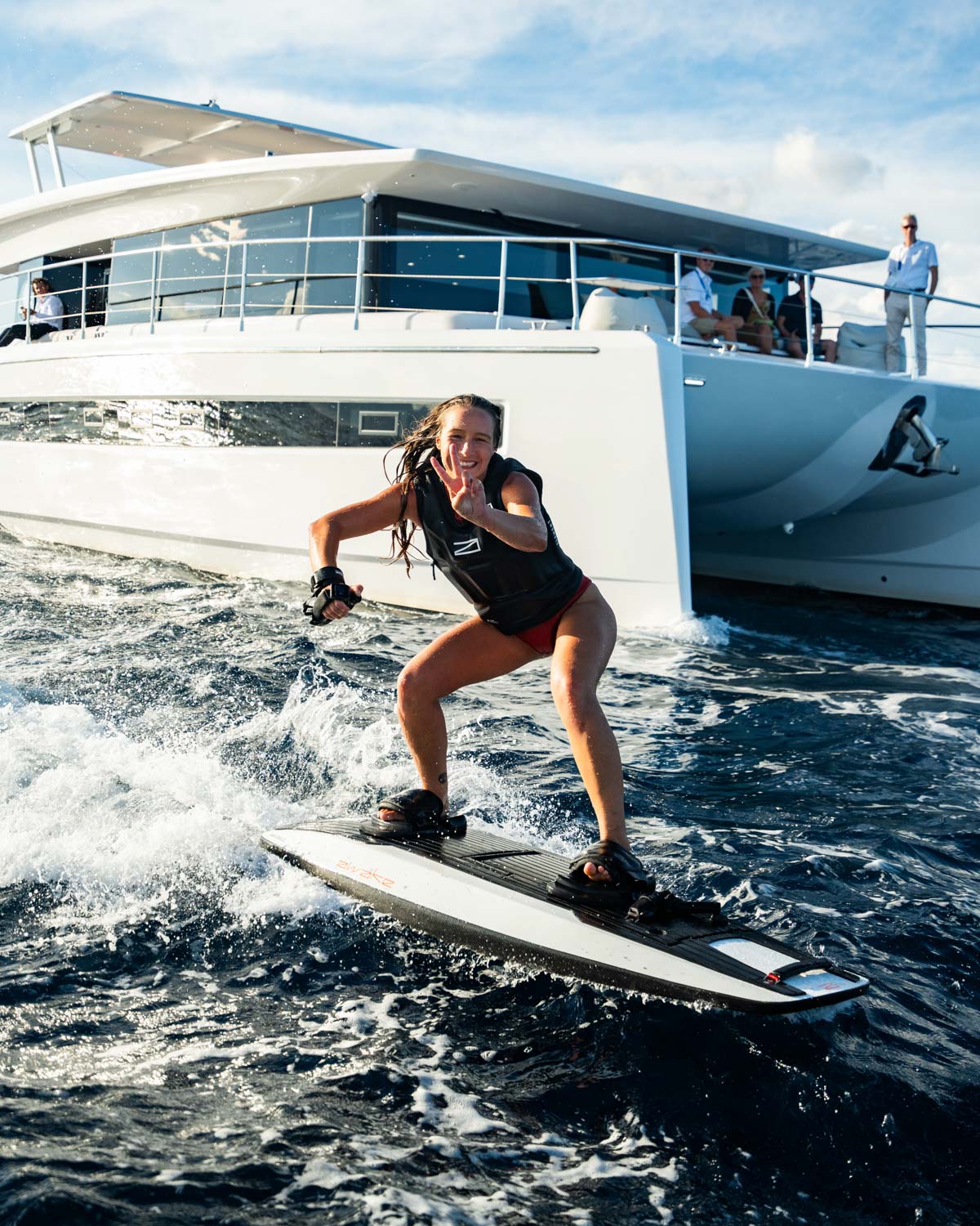 Awake Girl Riding RAVIK 3 with Yacht in the background