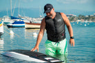 A smiling man wearing an Awake Life Vest and while looking at an Awake Jetboard.