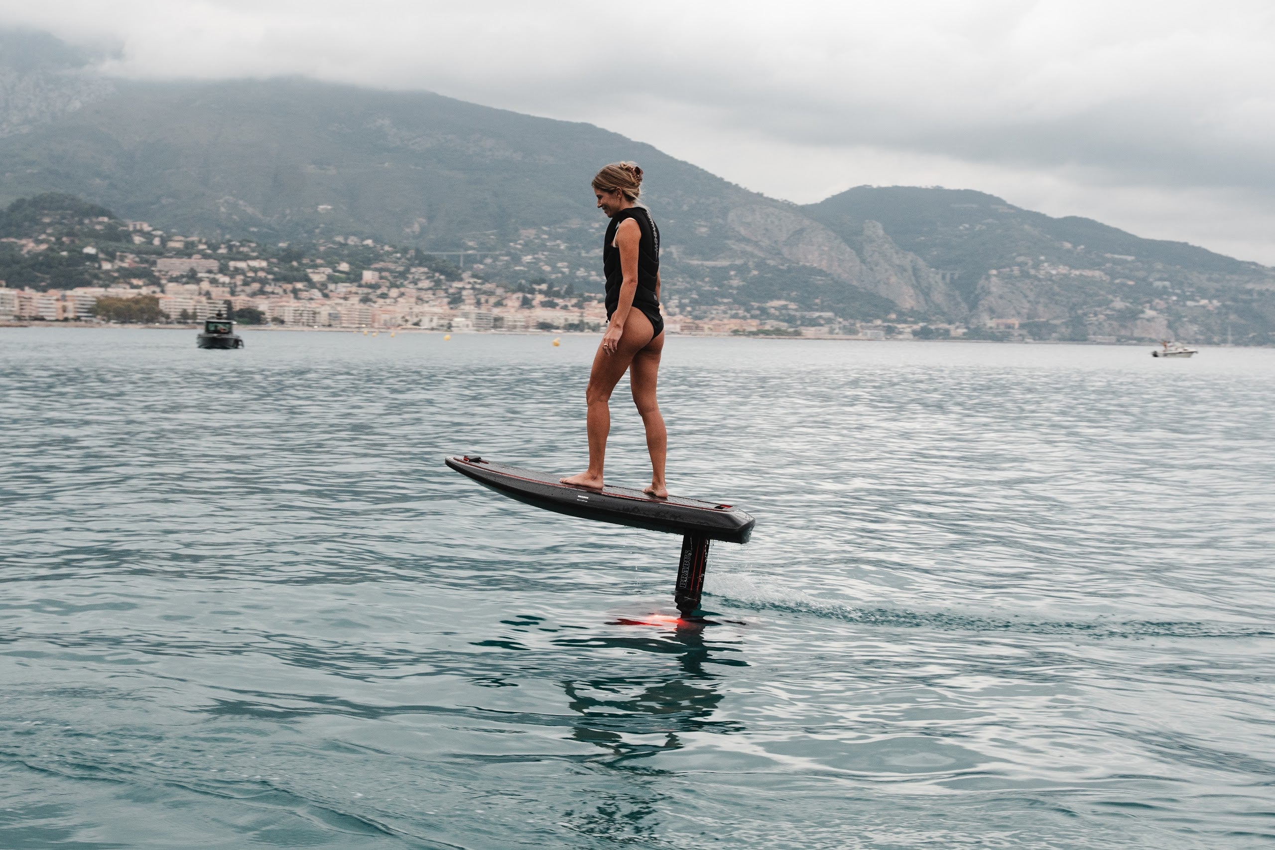Rider foiling on the BRABUS x Awake SHADOW CARVE with mountains behind