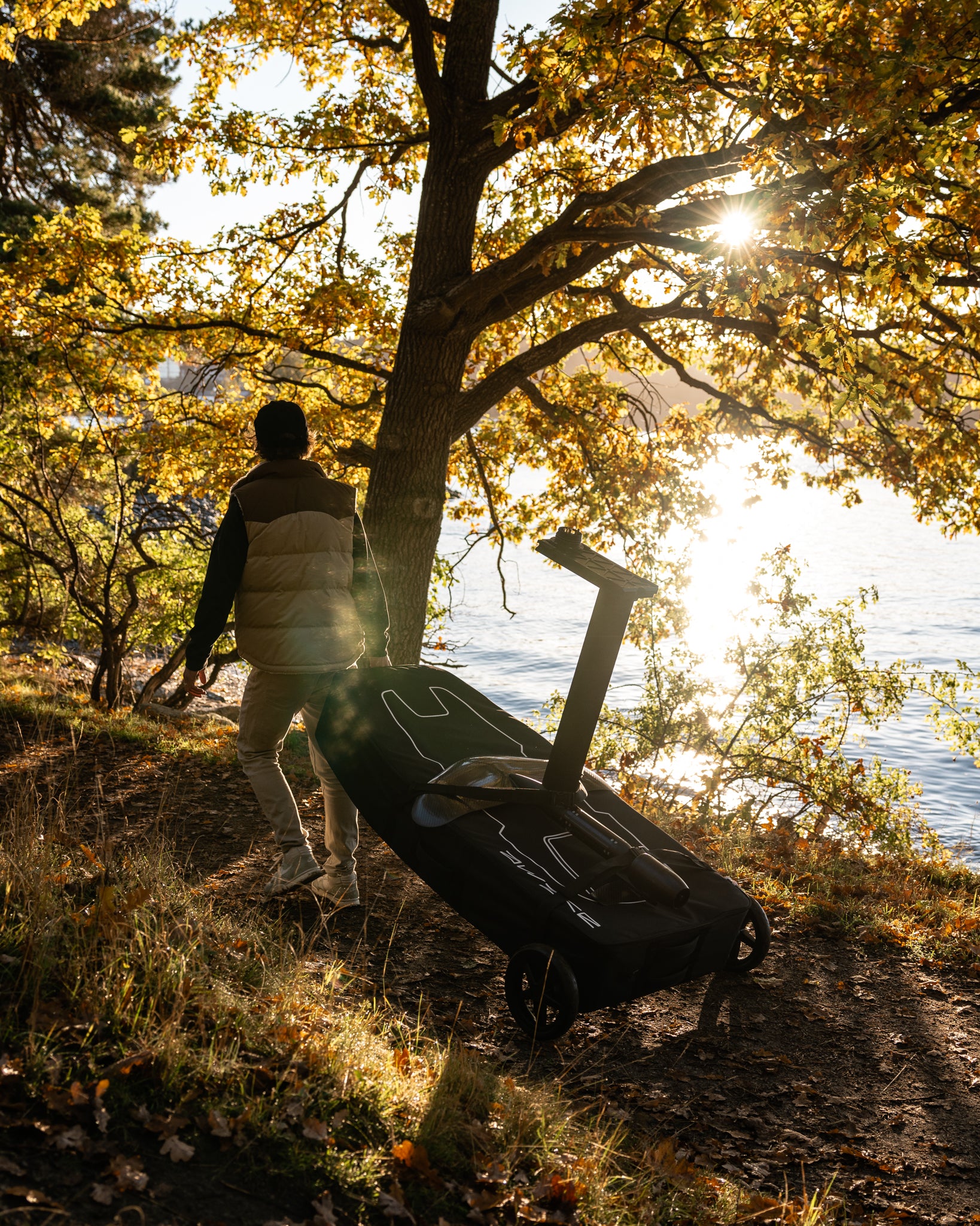 Man carrying Awake VINGA Board Bag Kit to the lake